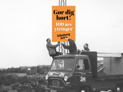 Sort og hvidt billede, hvor tre personer står på ladet og førehuset af en lastbil og fastgør en valgplakat i en lygtepæl. På plakaten på orange baggrund står teksten "gør dig hørt. 100 års ytringer. Silkeborg Arkiv"